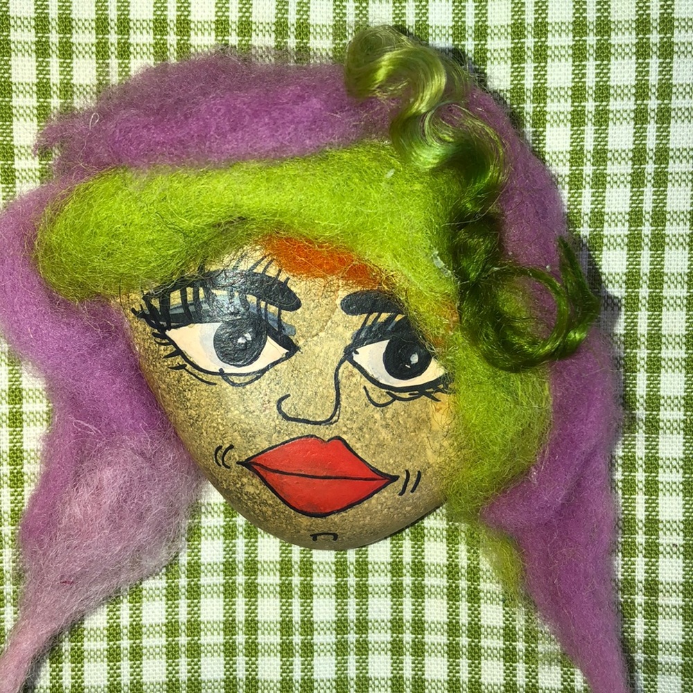 Faces painted on hand picked rocks, wool hair